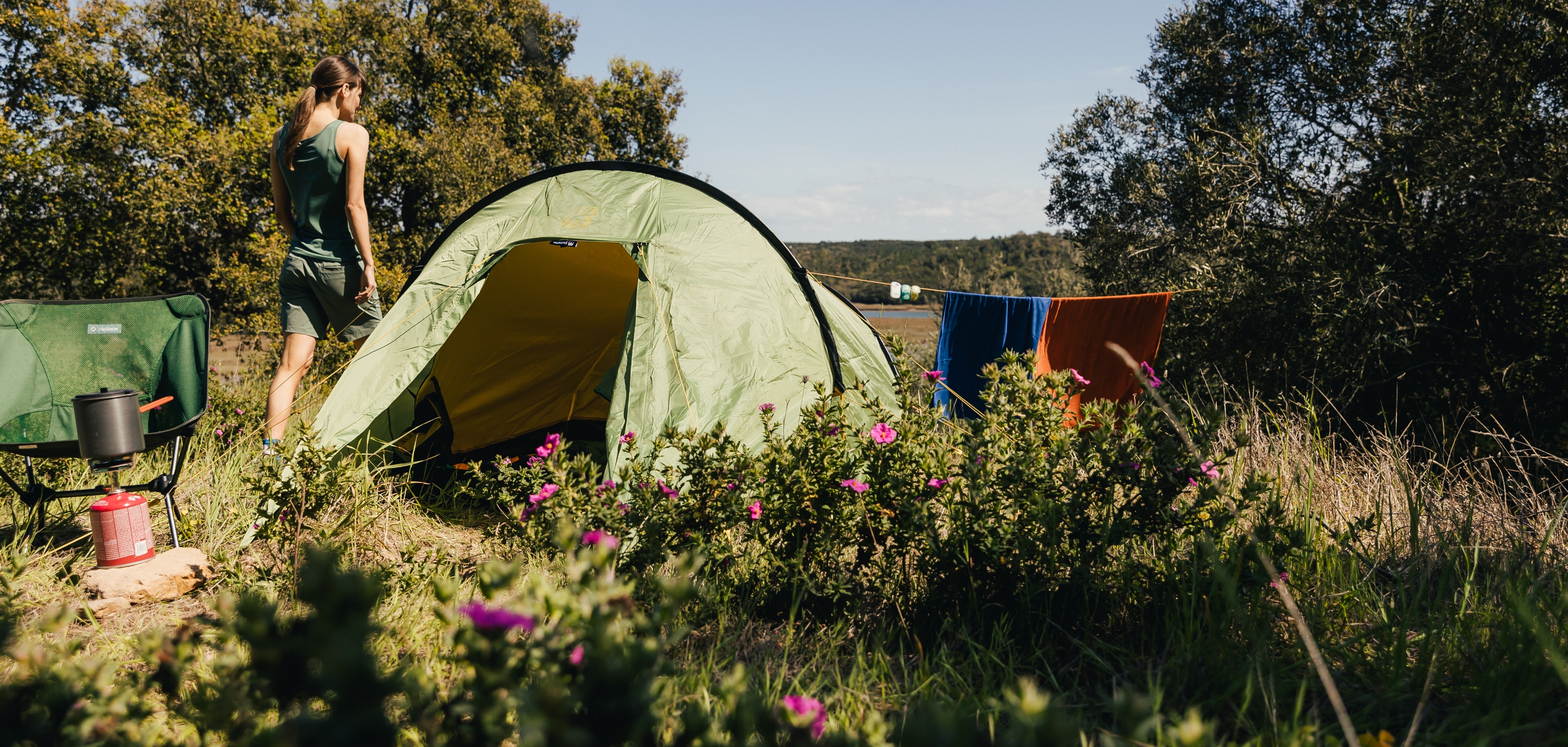 Vrouw laat handdoeken drogen buiten tent om de tent langer te laten meegaan